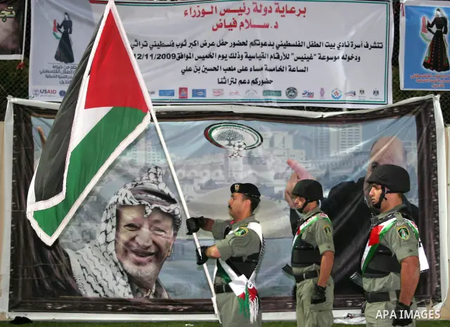 Palestinian policemen march at a presentation of a huge traditional embroidered dress at a soccer stadium in the West Bank city of Hebron, Thursday, Nov. 12, 2009. Photo by Najeh Hashlamoun