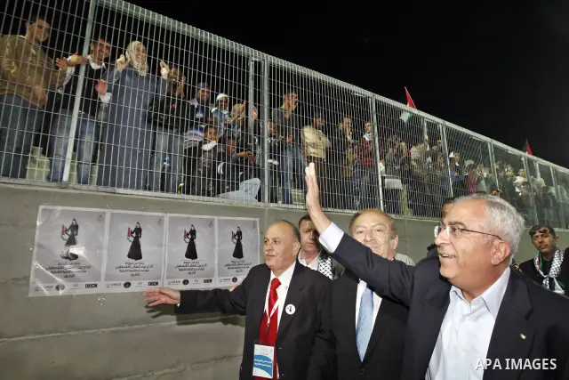 Palestinian Prime Minister Salam Fayyad during display the largest traditional Palestinian dress it will be to create the largest traditional Palestinian dress in an attempt to enter the Guinness World Records at Al-Huss...