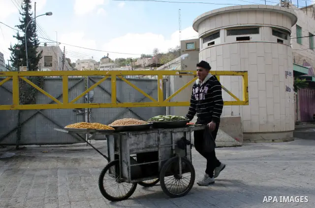 Palestinian man walks near the Israeli control room in the old part of Hebron on November 14, 2009.Photo by Najeh Hashlamoun