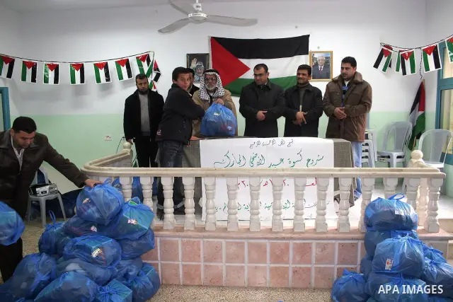 Islamic Charitable Projects Association distributes aid and clothes to the orphanage in Yata village southern the West Bank city of Hebron Wednesday, Nov. 25, 2009. Muslims worldwide are preparing for the Eid al-Adha fes...