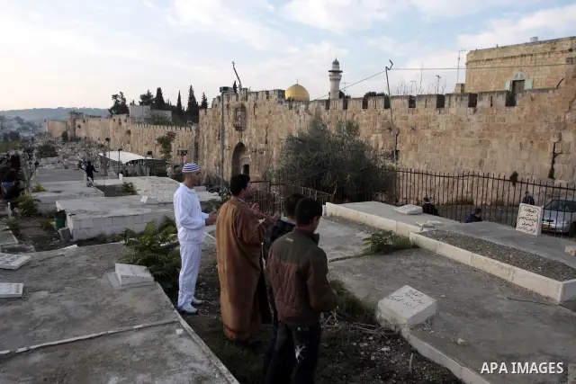 Palestinians visit the graves of their dead relatives, a tradition during the early hours of the first day of the Muslim holiday Eid Al-Adha, at the Muslim cemetery in Jerusalem, old city on Nov 27, 2009. Photo by Mohama...