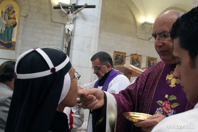 A Palestinian nun receives communion during Sunday mass at the Church of St. Catherine which is connected to the Church of the Nativity, in the West Bank town of Bethlehem,December 6, 2009.The church is built over the gr...