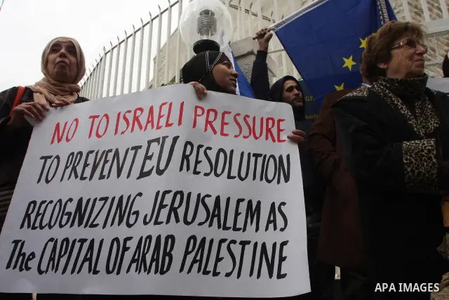 Palestinian demonstrators hold banners during a rally in front of the compound housing the French and Swedish consulates in east Jerusalem on December 7, 2009 in support of a draft EU proposal that east Jerusalem should...
