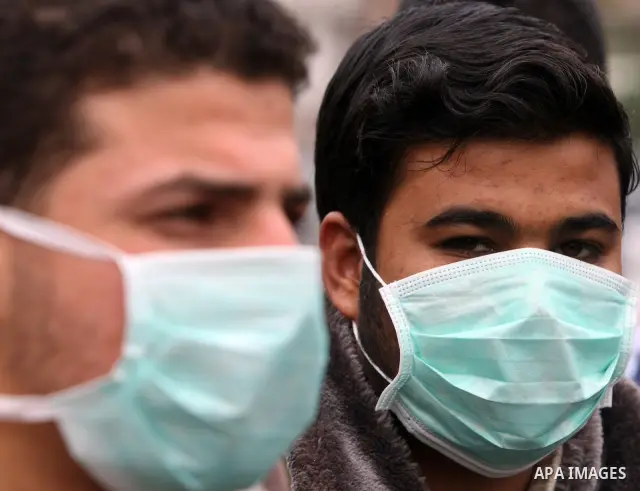 Palestinian men wear a protective masks as first cases of H1N1 flu infections have appeared, in Gaza City, 08 December 2009. According to the Health Ministery of the Hamas movement in Gaza, five people were infected by s...