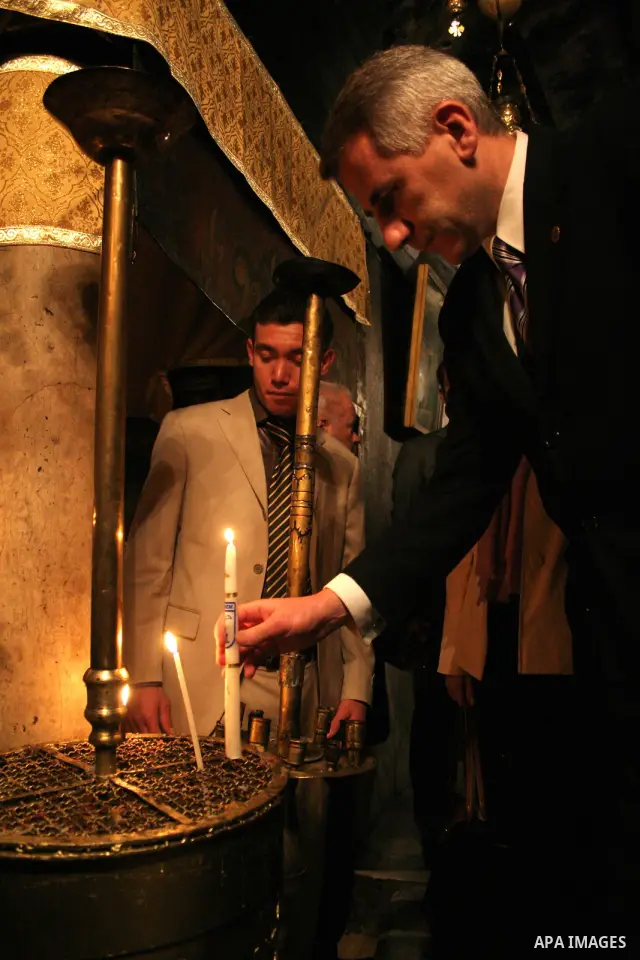 Lithuanian Foreign Minister Vygaudas Usackas lights a candle during his visit to the Church of the Nativity in the biblical West Bank city of Bethlehem on December 19, 2009.Photo by Najeh Hashlamoun