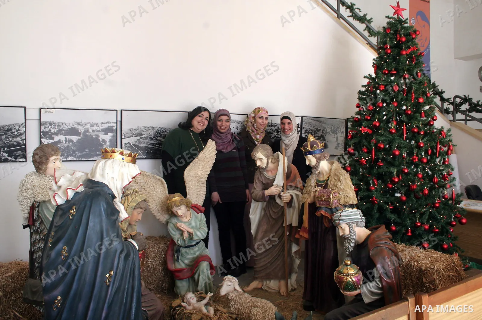 Palestinian Muslim girls pose for a photo with decorated Christmas trees inside the Center building in Manger square , in the biblical West Bank town of Bethlehem, Tuesday Dec. 23, 2009. Israeli Tourism Minister Stas Mes...