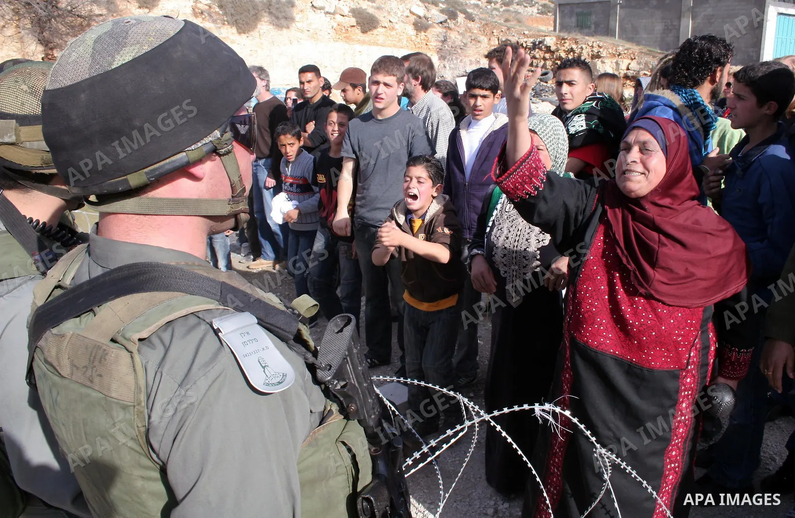Israeli soldiers and Israeli border policemen stand guard behind razor-wire as Palestinian , Israeli activists and International activists during a rally against Israel's separation barrier in the West Bank village of al...