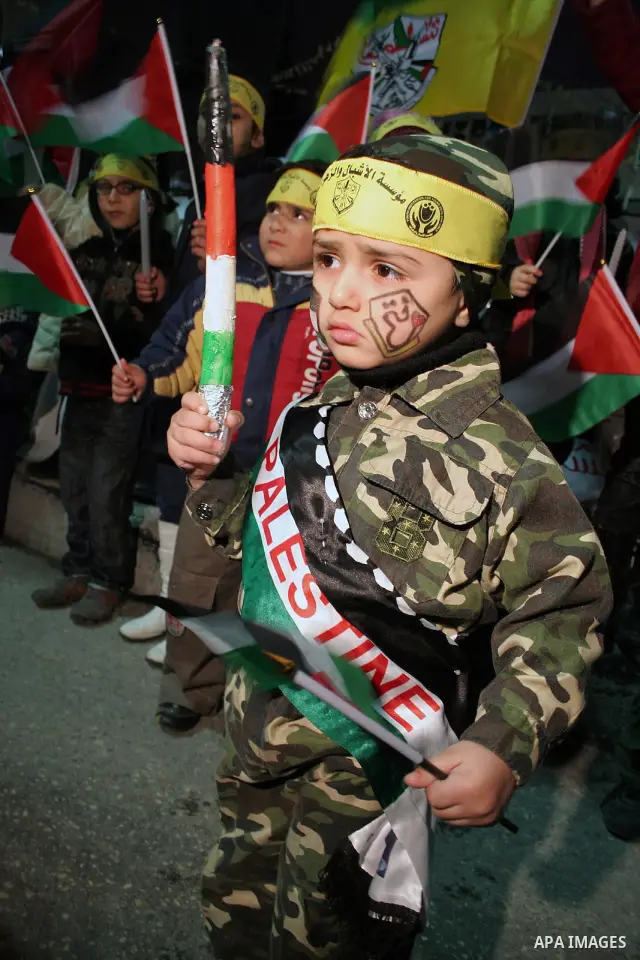 Palestinian children hold Palestinian flag and candles during anniversary of the start of the Fatah movement and Palestinian revolution in the West Bank city of Hebron, December 31, 2009. Photo by Najeh Hashlamoun