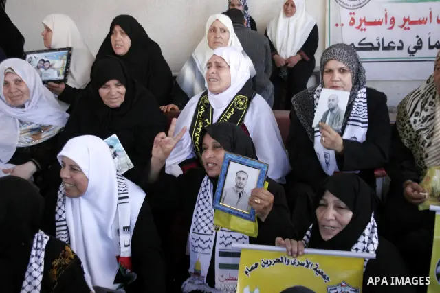 Palestinian women and children hold pictures of jailed relatives during a protest calling for the release of Palestinian prisoners from Israeli jails at the Red Cross office in Gaza City on April 5,2010. Photo by Yousef...