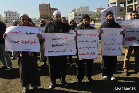Palestinians take part in a solidarity with Palestinian children at Yarmouk refugee camp in Syria in Gaza city on January 8, 2014. The Syrian army has besieged the Yarmouk Palestinian camp for a year as battles rage insi...