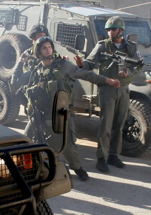Israeli soldiers scuffle with Palestinian and activist during a demonstration of Palestinian and foreign activists against the construction of the controversial Israeli separation barrier in the village of Maasarah, near...