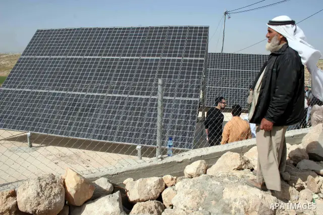 An elderly Palestinian man walks next to the solar cells in the village of Menezal near the West Bank city of Hebron, February 18 ,2010. Photo by Najeh Hashlamoun.