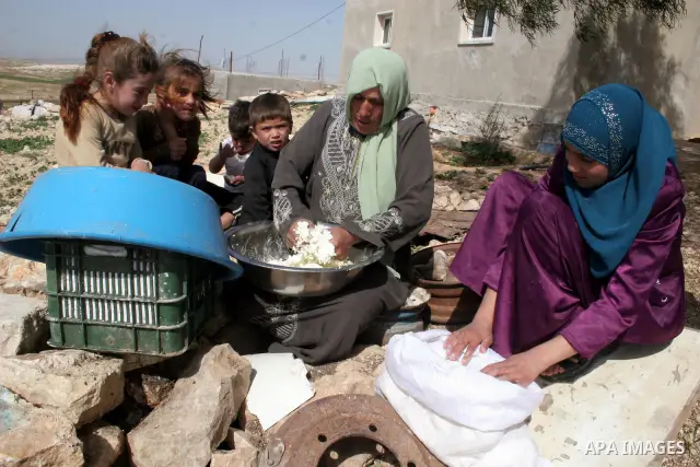 A Palestinian making yoghurt-based food called 'Keseek' in the village of Menezal near the West Bank city of Hebron, February 19 ,2010. next to the separation barrier. They make their living from raising animals and basi...
