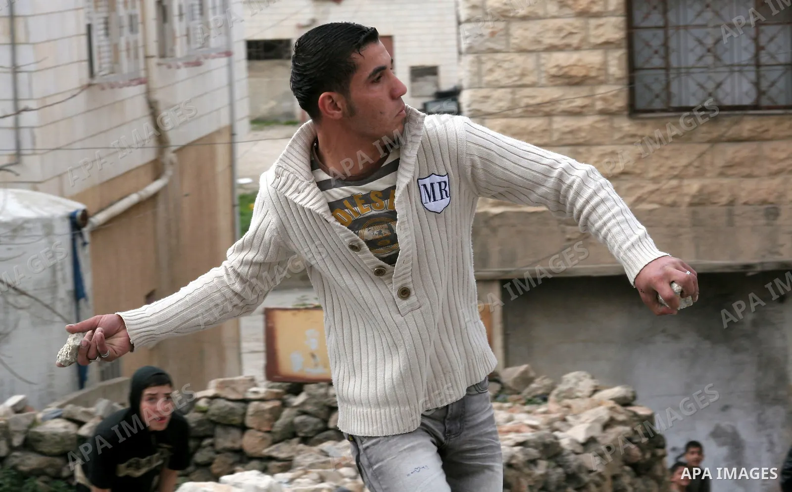 Palestinian youth throws stones at Israeli soldiers in the West Bank city of Hebron February 24, 2010, after Israel's Prime Minister Benjamin Netanyahu was quoted in a statement as saying that the Tomb of the Patriarchs,...