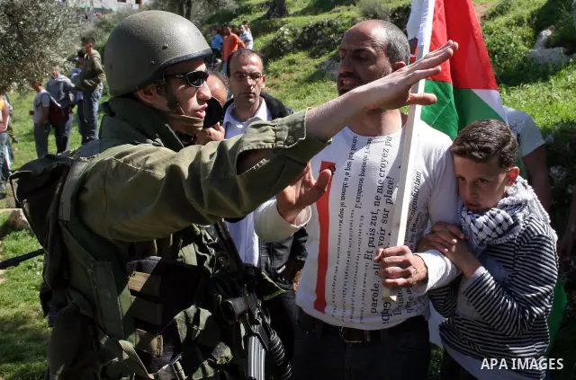 Palestinians hold flags during a demonstration against the construction of a section of the controversial Israeli barrier in the West Bank town of Beit Jala near Bethlehem March 7, 2010. Photo by Najeh Hashlamoun