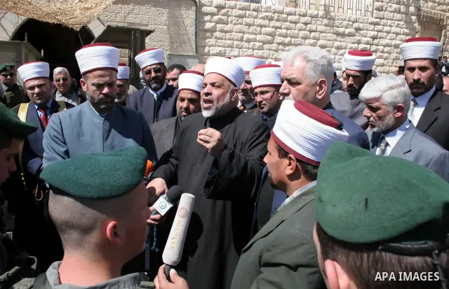 Israeli soldiers stand guard as Palestinian Muslim clerics hold a press conference next to the Ibrahimi mosque protesting Israeli decision to include West Bank Shrines to their heritage sites in the West Bank city of Heb...