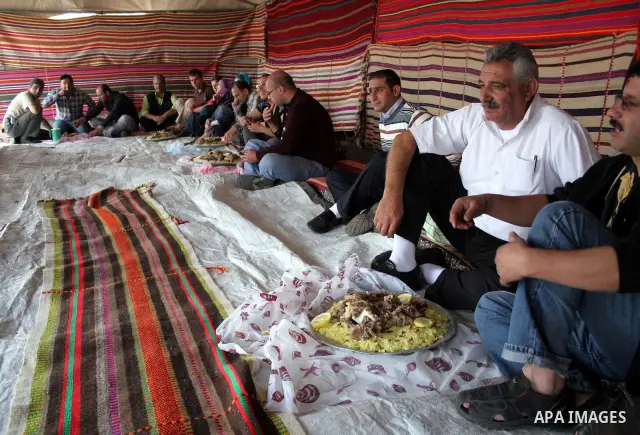 Palestinian men prepare food in a tent which is used as a shared kitchen in the mountains of the Israeli settlement of Carmel, in the south of West Bank city of Hebron on 24 March 2010. Photo by Najeh Hashlamoun