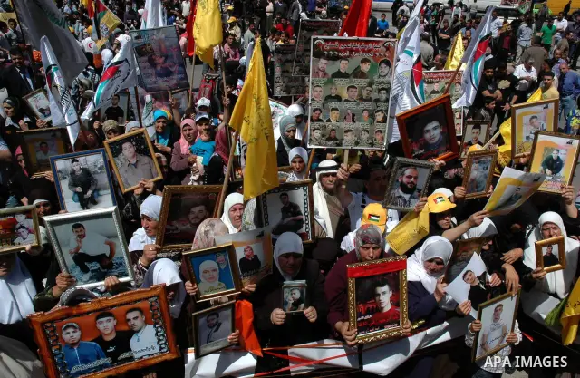 Palestinians hold pictures of their jailed relatives during a protest in the West Bank city of Nablus April 15, 2010, calling for the release of Palestinian prisoners from Israeli jails. Palestinians mark Palestinian Pri...