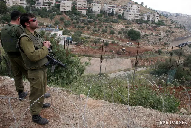 Israeli soldiers stand guard during a demonstration by foreign activists and Palestinians against the extension of Israel's controversial separation barrier in the Palestinian West Bank village of Beit Jala, south of Jer...