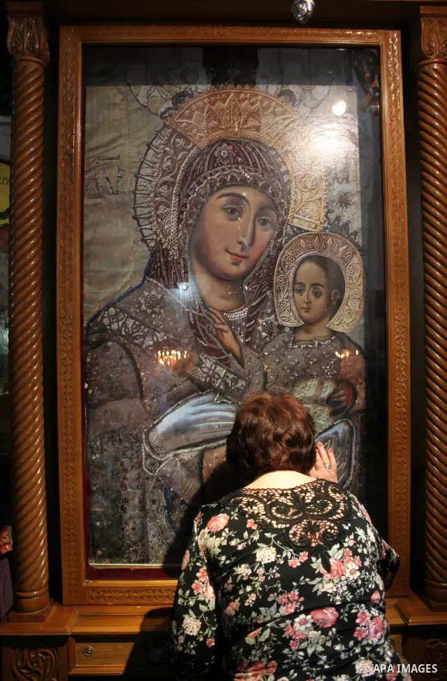 Christians praying inside the 'Grotto,' or cave, in the Church of the Nativity, the traditionally accepted birhtplace of Jesus Christ, in the West Bank town of Bethlehem on April 22 2010, whose wall's are lined with pain...