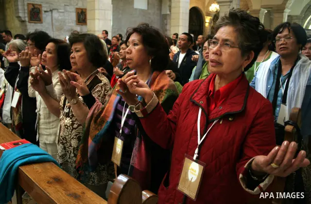 Christians praying inside the 'Grotto,' or cave, in the Church of the Nativity, the traditionally accepted birhtplace of Jesus Christ, in the West Bank town of Bethlehem on April 22 2010, whose wall's are lined with pain...