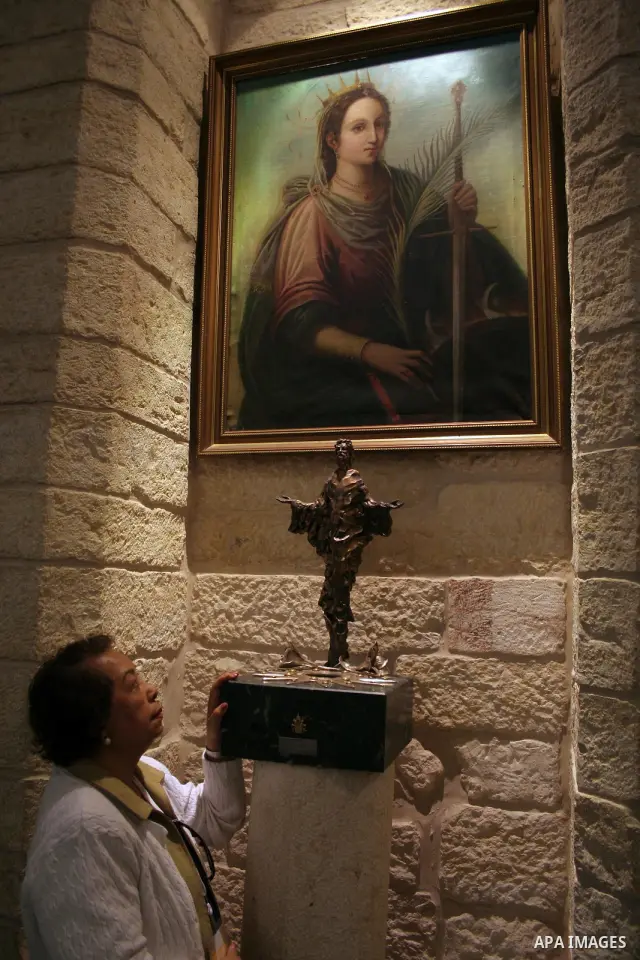 Christians praying inside the 'Grotto,' or cave, in the Church of the Nativity, the traditionally accepted birhtplace of Jesus Christ, in the West Bank town of Bethlehem on April 22 2010, whose wall's are lined with pain...