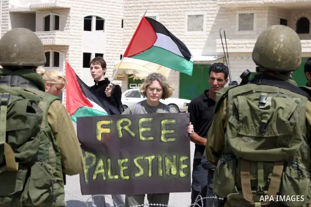 Israeli soldiers stand guards as Palestinian , Israeli activists and International activists take part in a demonstration against Israel's controversial separation barrier in the West Bank village of Walajeh near the Pal...