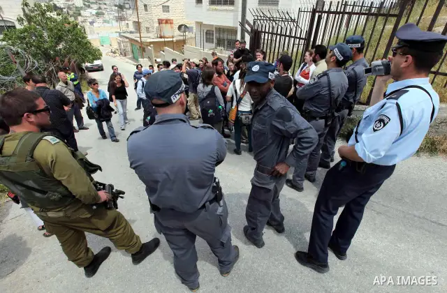 Israeli forces guard a group of left-wing Israelis who came to visit Palestinian families living close to Jewish settlers in the divided West Bank city of Hebron on April 23,2010. Photo by Najeh Hashlamoun .
