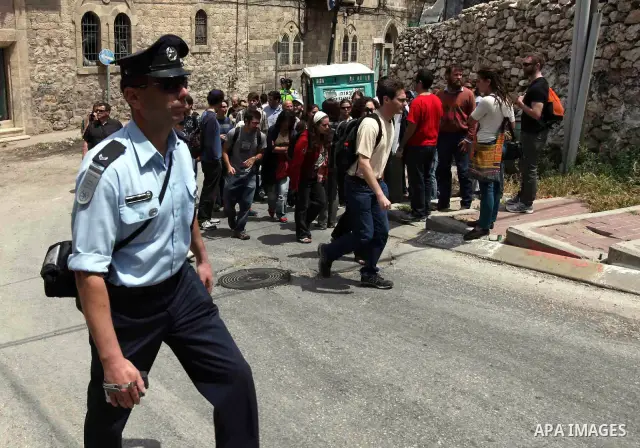 Israeli forces guard a group of left-wing Israelis who came to visit Palestinian families living close to Jewish settlers in the divided West Bank city of Hebron on April 23,2010. Photo by Najeh Hashlamoun .