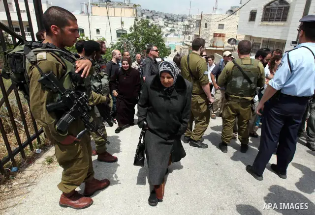 Israeli forces guard a group of left-wing Israelis who came to visit Palestinian families living close to Jewish settlers in the divided West Bank city of Hebron on April 23,2010. Photo by Najeh Hashlamoun .