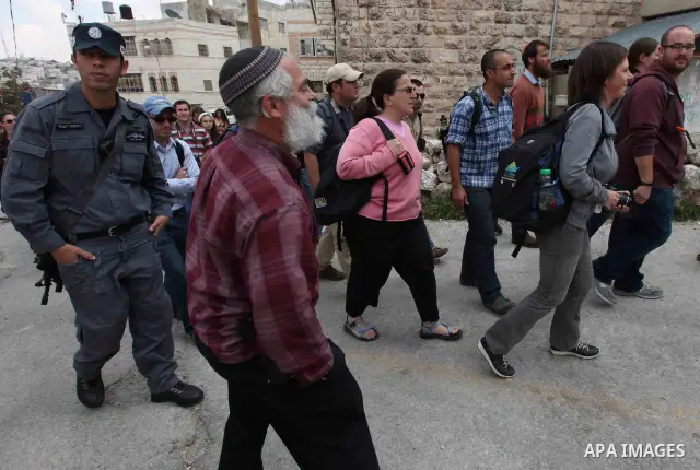 Israeli forces guard a group of left-wing Israelis who came to visit Palestinian families living close to Jewish settlers in the divided West Bank city of Hebron on April 23,2010. Photo by Najeh Hashlamoun .