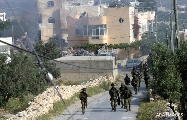 Israeli soldiers and Israeli border police officers operate in the West Bank village of Beit Awwa, near Hebron, Monday, April 26, 2010. Witnesses say Israeli forces have killed a Hamas fugitive in a raid on a West Bank h...