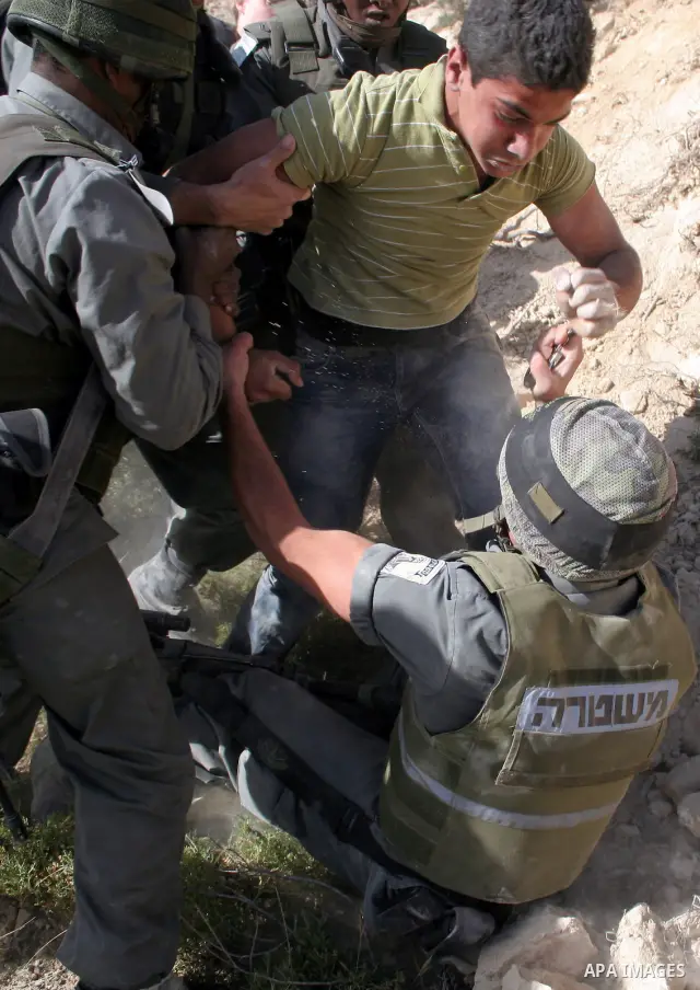 A Palestinian protester is arrested by Israeli border police during a demonstration against the construction of the controversial Israeli barrier in the West Bank village of al Wallaje near Bethlehem April 27, 2010. Acco...