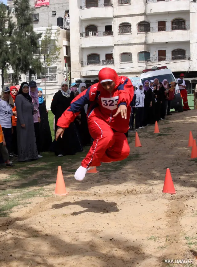 A Palestinian woman competes barefoot in the long jump during a local athletics competition at Palestine Stadium in Gaza City on May 8, 2010. Photo by Mohammed Asad