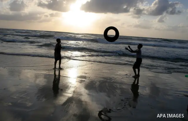 Palestinian children play during sunset on the beach of Gaza City May 19, 2010. Photo by Ashraf Amra