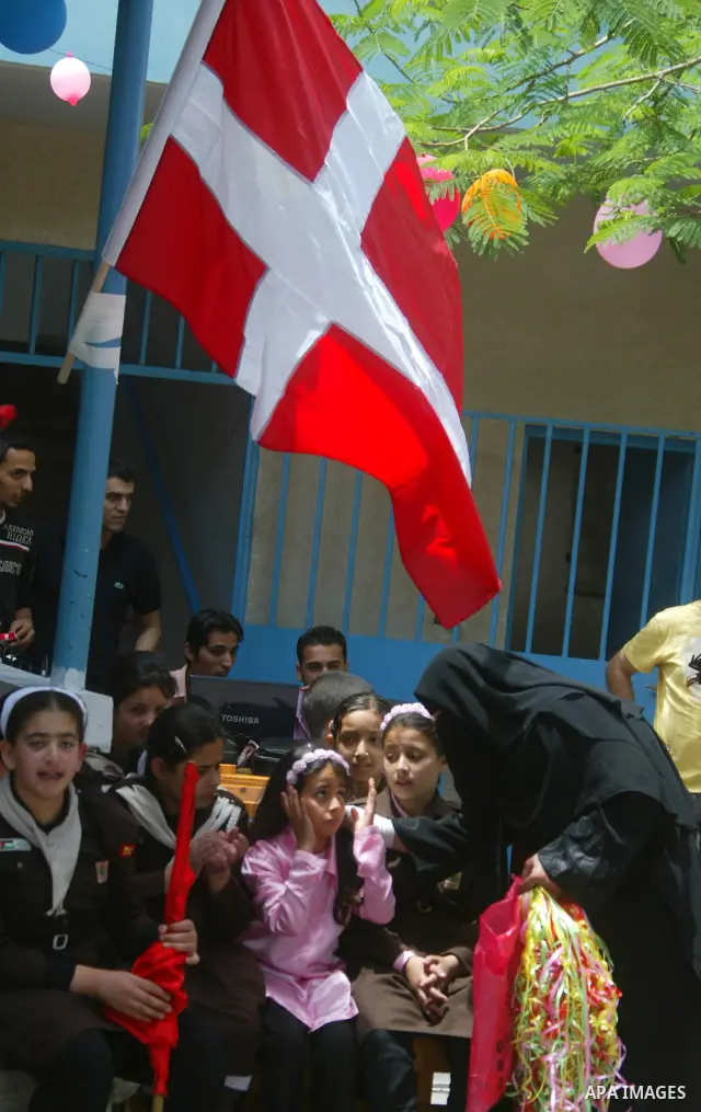 Palestinian school girls wave the Danish flag upon the arrival of a Danish diplomatic delegation to the UN-run school in Khan Yunis, southern Gaza Strip, on May 20, 2010. The delegation arrived in the Gaza Strip today br...