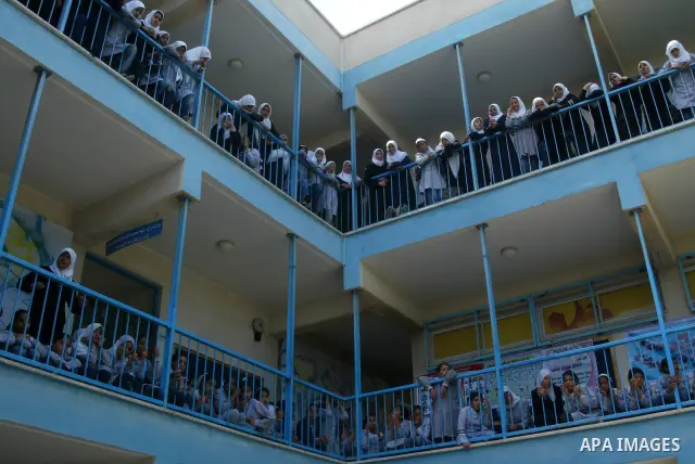 Palestinian school girls watch from the balcony of their school the arrival of a Danish diplomatic delegation to the UN-run school in Khan Yunis, southern Gaza Strip, on May 20, 2010. The delegation arrived in the Gaza S...