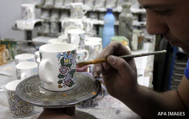 Palestinian worker decorates and paints on the ceramics in the West Bank city of Hebron on May 20, 2010. This factory creates artifacts and Judaic made of glass and ceramics . these kinds of products are main products th...