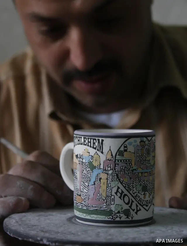 Palestinian worker decorates and paints on the ceramics in the West Bank city of Hebron on May 20, 2010. This factory creates artifacts and Judaic made of glass and ceramics . these kinds of products are main products th...