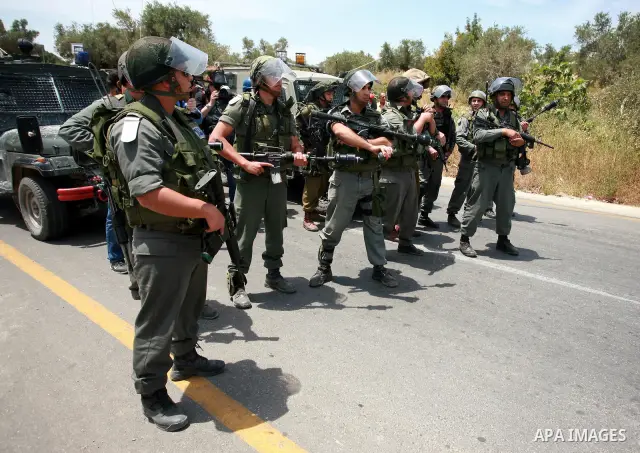 Israeli troops stand guards during clashes following a demonstration in the West Bank village of Nabi Saleh on May 21, 2010 against the expansion of the nearby Jewish settlement of Halamish . Israeli forces shot dead two...