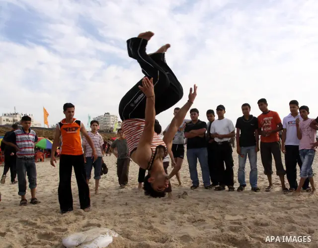 A Palestinian youth jumps on the beach of Gaza City on May 21,2010. Photo by Mohammed Asad