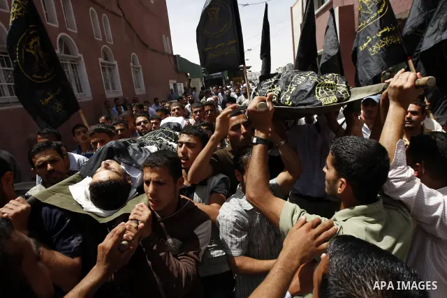 Palestinians carry the bodies of Nader Abu Daka and Hamed Abu Hamad during their funeral in Khan Younis in the southern Gaza Strip May 22, 2010. Israeli troops killed Abu Daka and Abu Hamad, two armed Palestinians who cr...