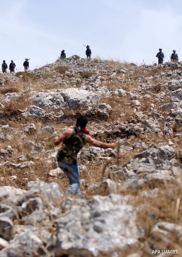 A Palestinian youth uses a sling to hurl stones at Israeli troops during clashes in the village of Iraq Burin near the West Bank city of Nablus on May 21, 2010. Photo by Wagdi Eshtayah