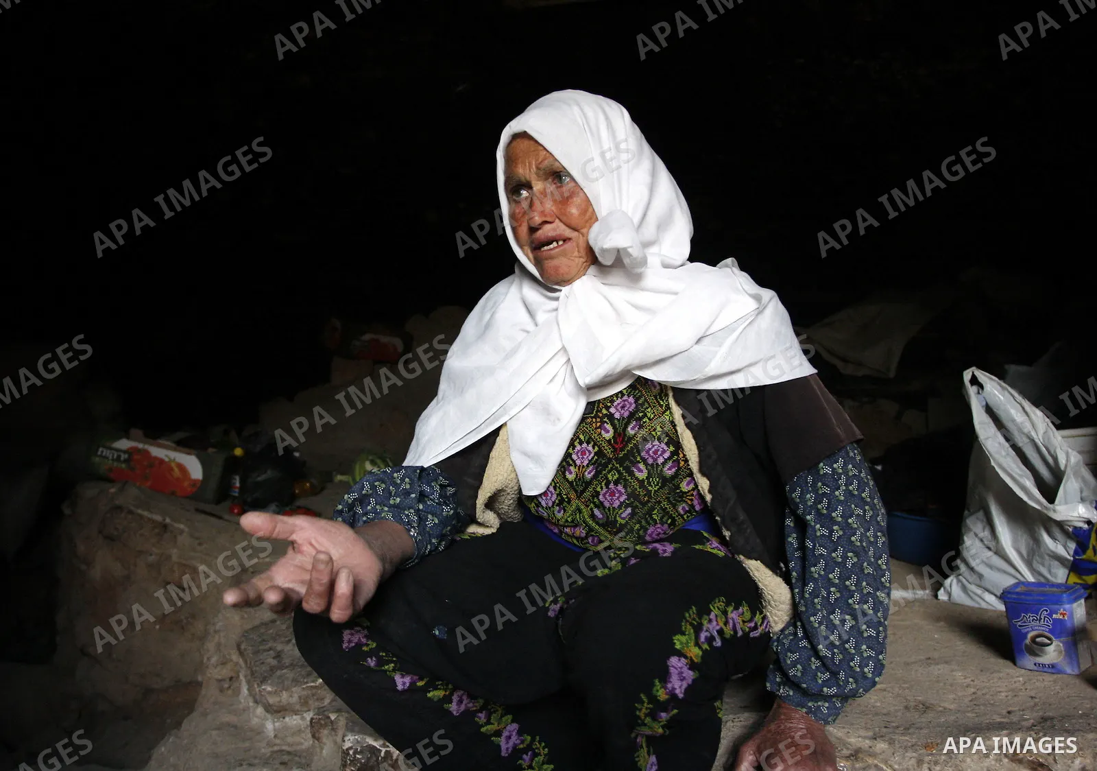 Palestinian woman sits inside a cave in a mountainous area outside the city of Hebron in the occupied West Bank on May 22, 2010. Photo by Mamoun Wazwaz