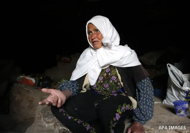 Palestinian woman sits inside a cave in a mountainous area outside the city of Hebron in the occupied West Bank on May 22, 2010. Photo by Mamoun Wazwaz