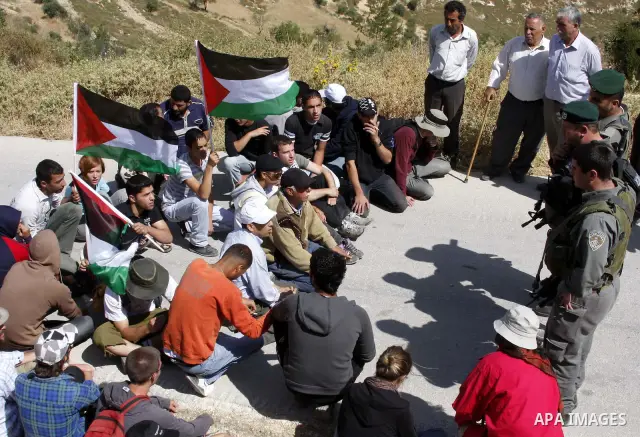 Palestinians and foreign activists take part in a demonstration against the construction of the controversial Israeli barrier in the village of al Wallaje near the West Bank city of Bethlehem on May 23, 2010. Photo by Ma...