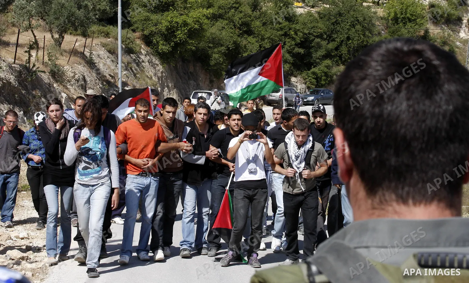 Palestinians and foreign activists take part in a demonstration against the construction of the controversial Israeli barrier in the village of al Wallaje near the West Bank city of Bethlehem on May 23, 2010. Photo by Ma...