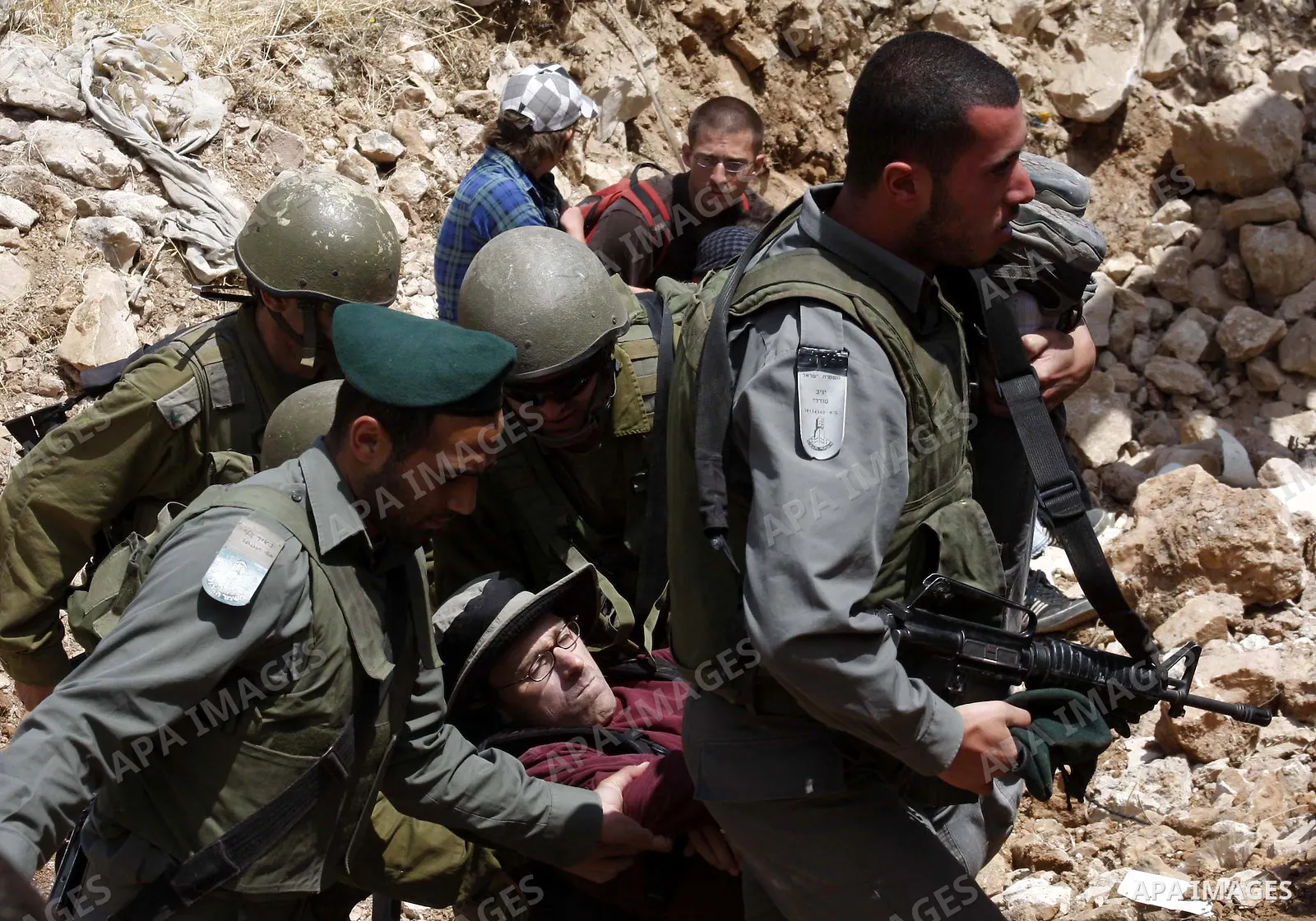 Israeli forces carry away a protester during a demonstration by Palestinian, Israeli and foreign activists against Israel's controversial separation barrier in the West Bank town of Beit Jala near Bethlehem on 23 May 201...