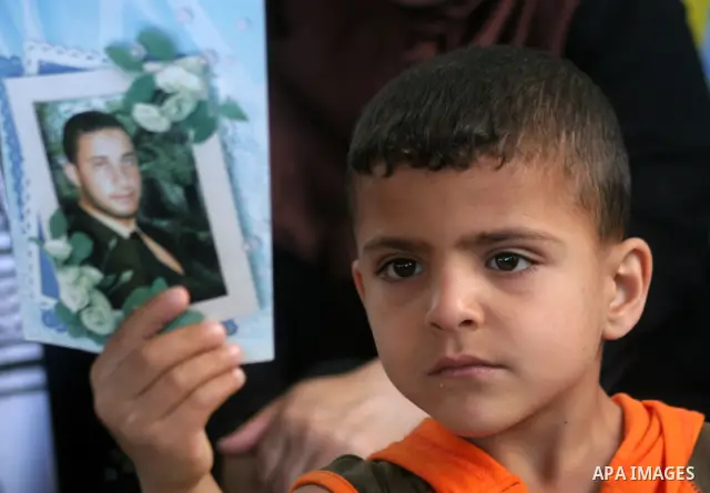 Palestinian child holds a picture of jailed relative during a protest calling for the release of Palestinian prisoners from Israeli jails at the Red Cross office in Gaza City on May 24,2010. Photo by Ashraf Amra