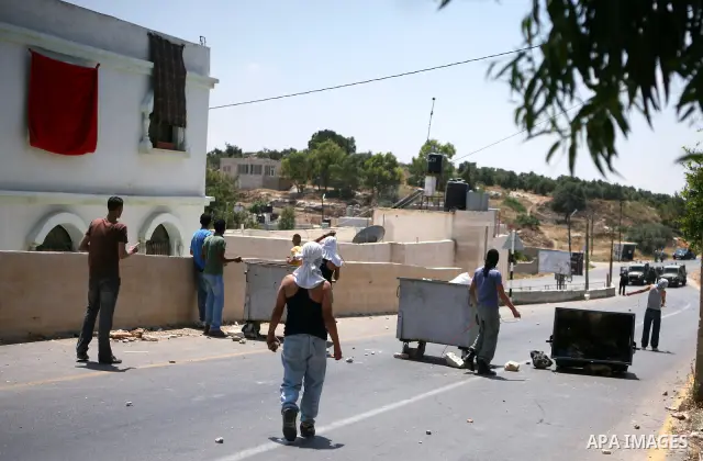 Palestinian youths hurl stones at Israeli soldiers during clashes in the West Bank village of Nabi Saleh, on 28 May 2010. Palestinians protest weekly against the neighbouring Jewish settlement of Halamish. photo by Eyad...